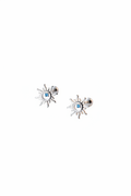Macro shot of The Solis Azure Stud earrings, showcasing the sunburst silver design and a brilliant blue zircon center stone.