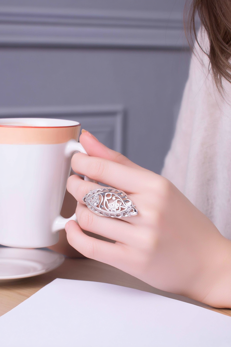 Intricate 925 sterling silver filigree shield ring featuring a hollow-out floral lace pattern, handcrafted statement jewelry by Nura Label.