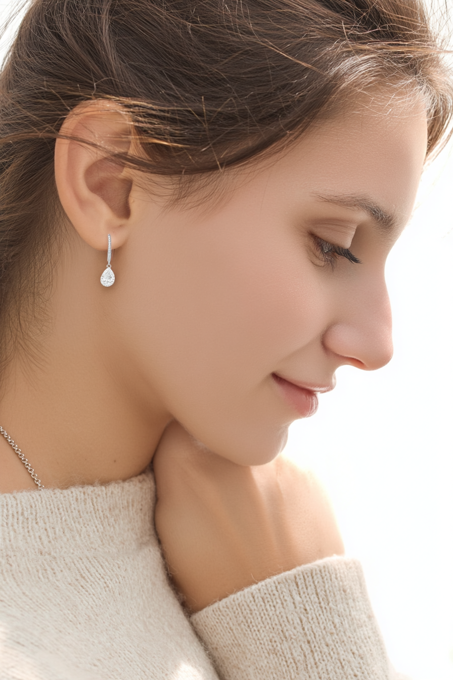 Close-up of The Lyra drop earrings featuring a brilliant clear teardrop-shaped stone in a high-polish solid 925 sterling silver setting.