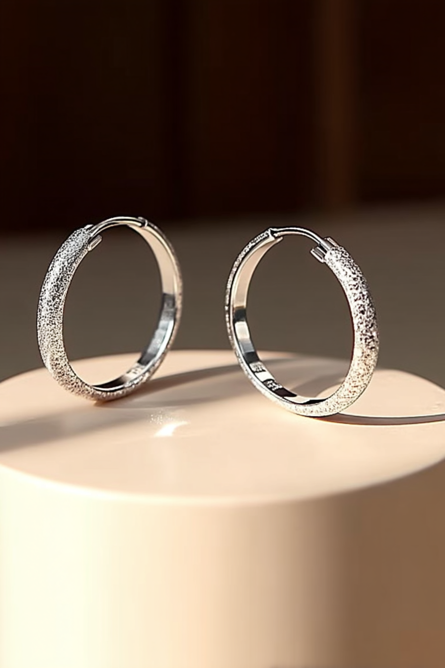 Close-up of The Étoile textured hoops, showcasing the sparkling frosted stardust finish on solid 925 sterling silver circles.