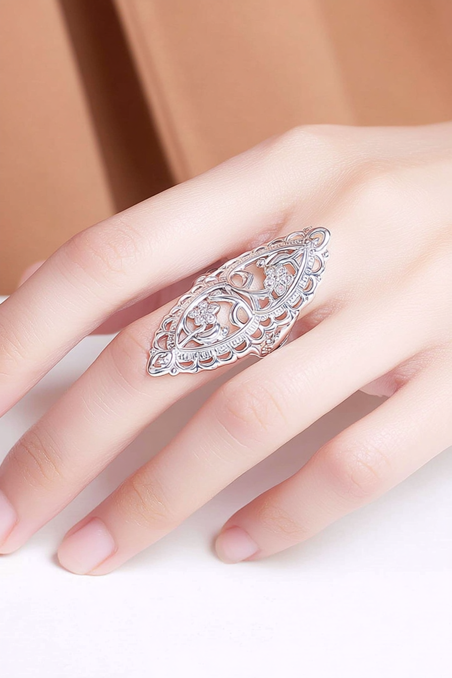 Intricate 925 sterling silver filigree shield ring featuring a hollow-out floral lace pattern, handcrafted statement jewelry by Nura Label.