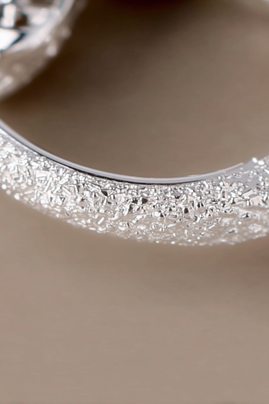 Close-up of The Étoile textured hoops, showcasing the sparkling frosted stardust finish on solid 925 sterling silver circles.