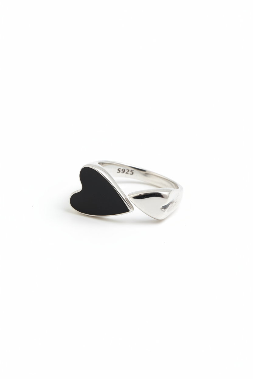 Minimalist 925 sterling silver ring featuring a central black heart-shaped emblem, handcrafted vintage-style jewelry by Nura Label.