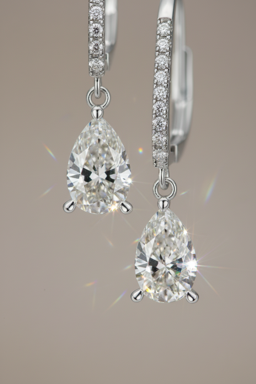 Close-up of The Lyra drop earrings featuring a brilliant clear teardrop-shaped stone in a high-polish solid 925 sterling silver setting.