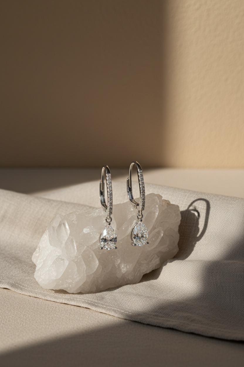 Close-up of The Lyra drop earrings featuring a brilliant clear teardrop-shaped stone in a high-polish solid 925 sterling silver setting.