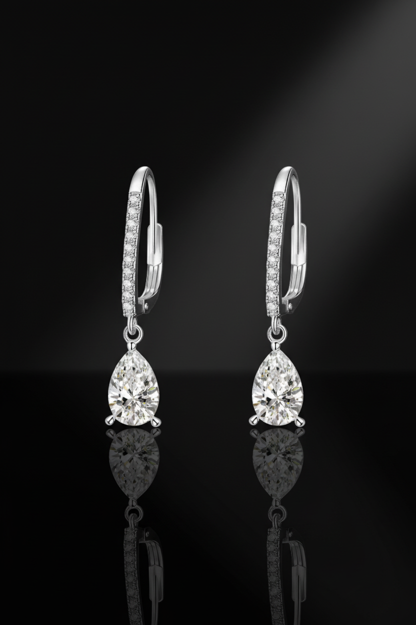Close-up of The Lyra drop earrings featuring a brilliant clear teardrop-shaped stone in a high-polish solid 925 sterling silver setting.