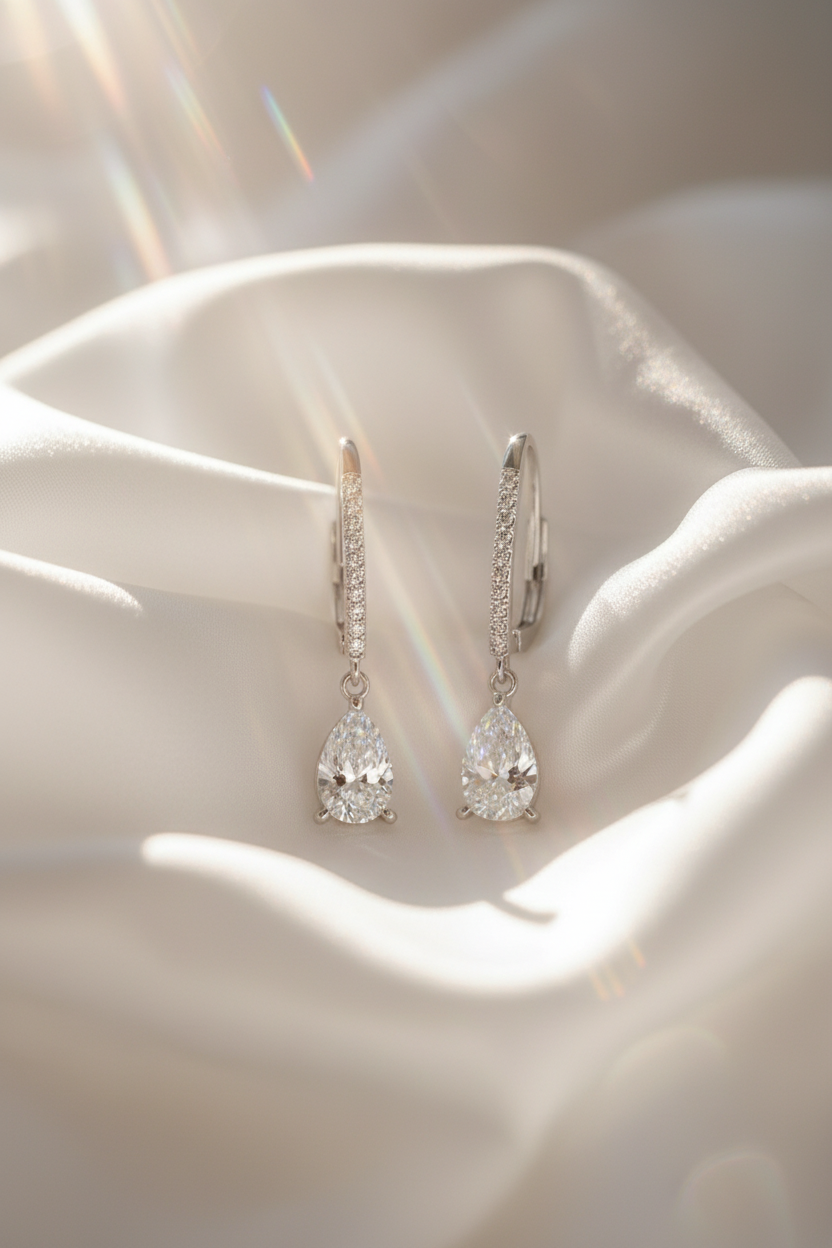 Close-up of The Lyra drop earrings featuring a brilliant clear teardrop-shaped stone in a high-polish solid 925 sterling silver setting.