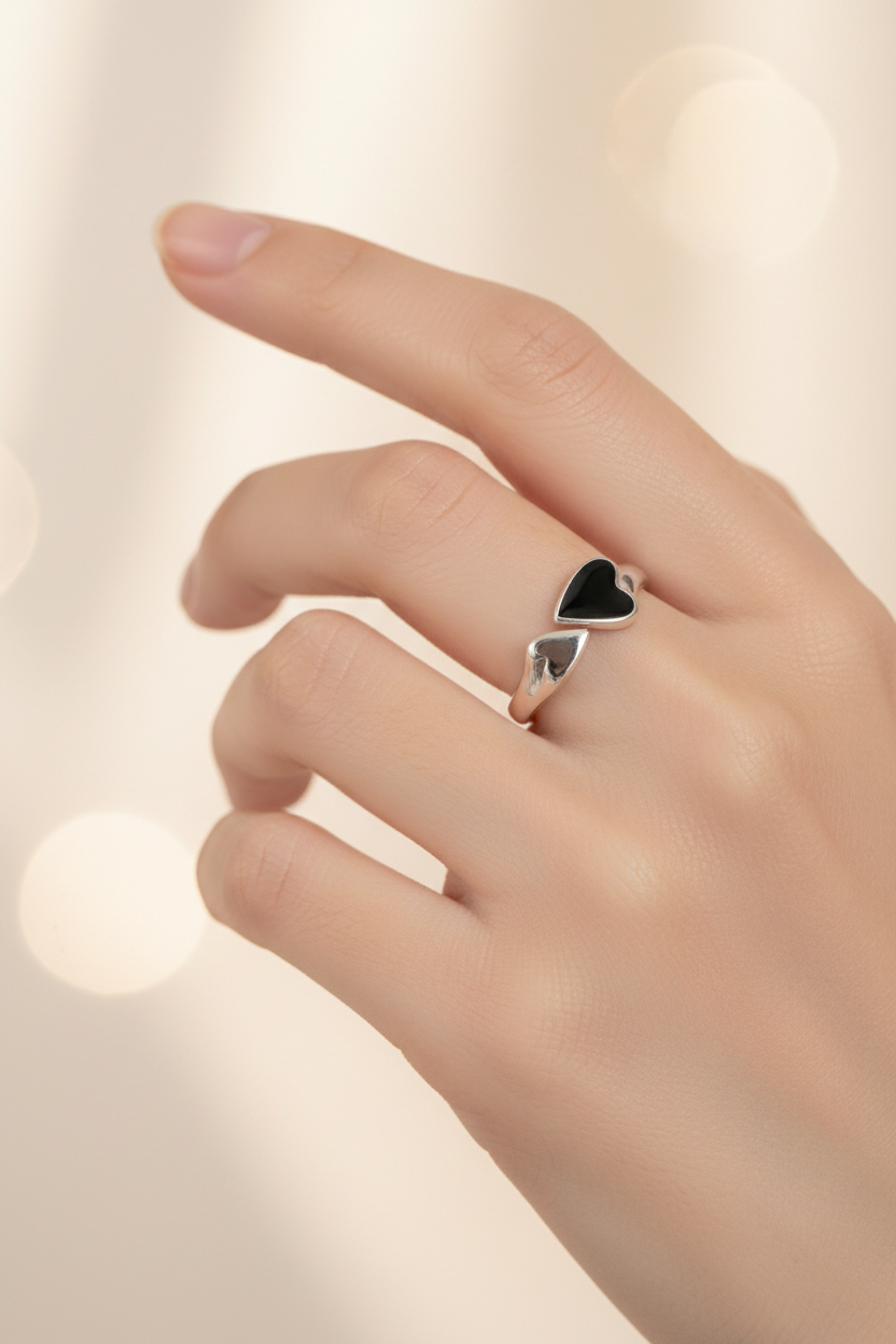 Minimalist 925 sterling silver ring featuring a central black heart-shaped emblem, handcrafted vintage-style jewelry by Nura Label.
