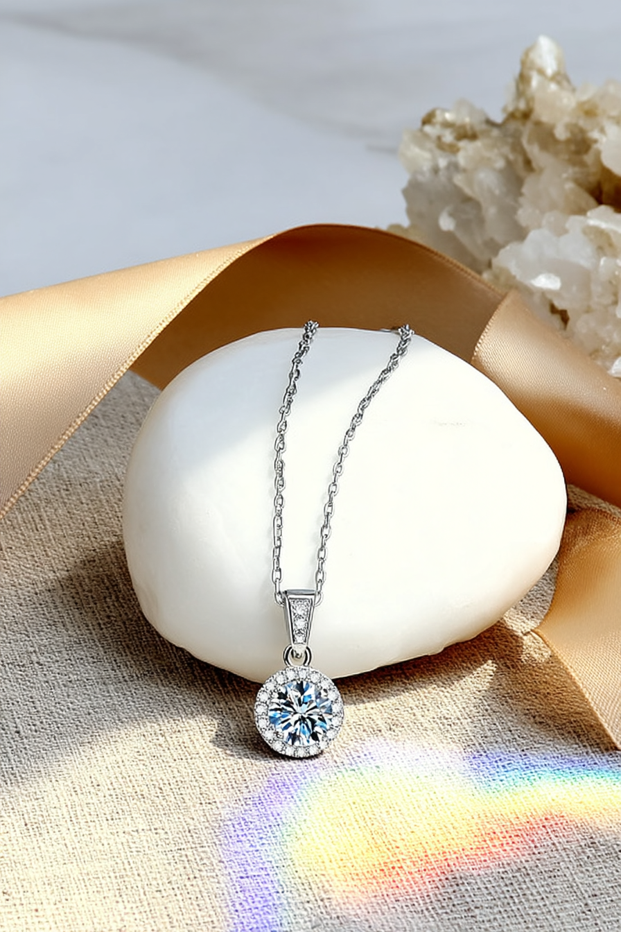 Close-up of The Lyra pendant, featuring a brilliant 1.0 carat round-cut moissanite inside a classic round pavé halo in solid 925 silver.