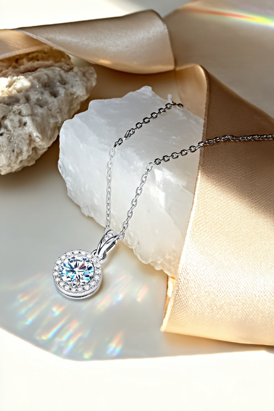 Close-up of The Lyra pendant, featuring a brilliant 1.0 carat round-cut moissanite inside a classic round pavé halo in solid 925 silver.
